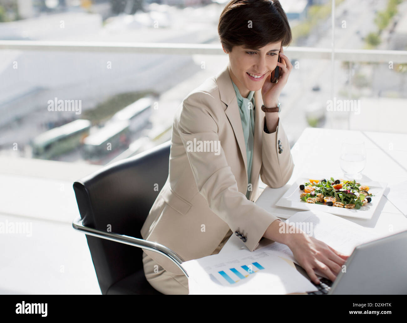 Businesswoman multitasking at desk Stock Photo