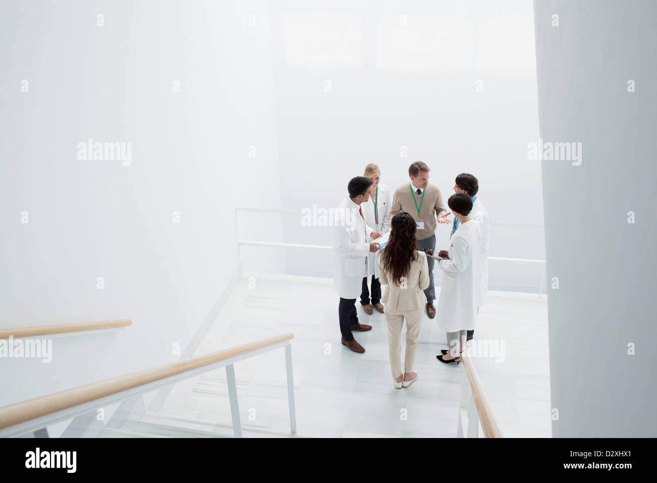 Business people and doctors on landing of stairs Stock Photo
