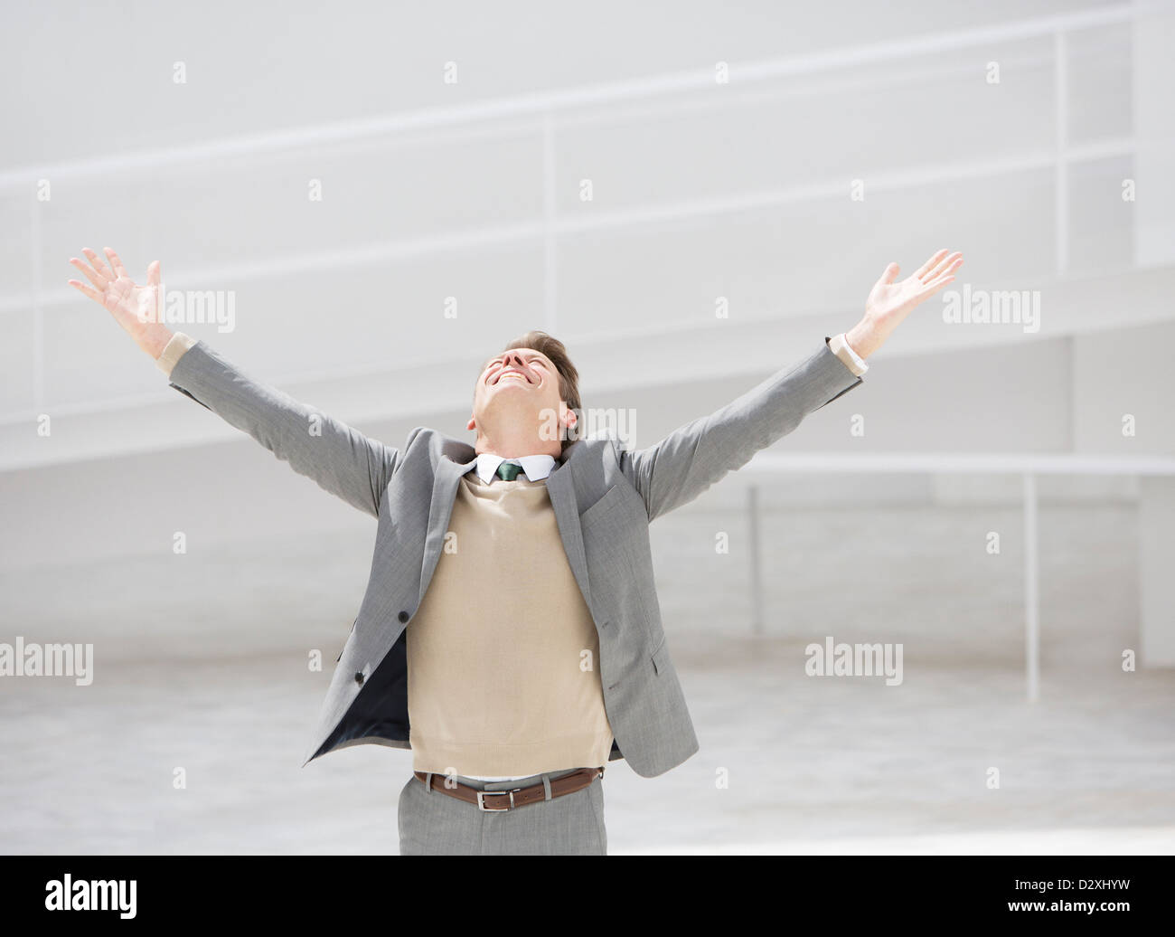 Exuberant businessman with head back and arms outstretched Stock Photo