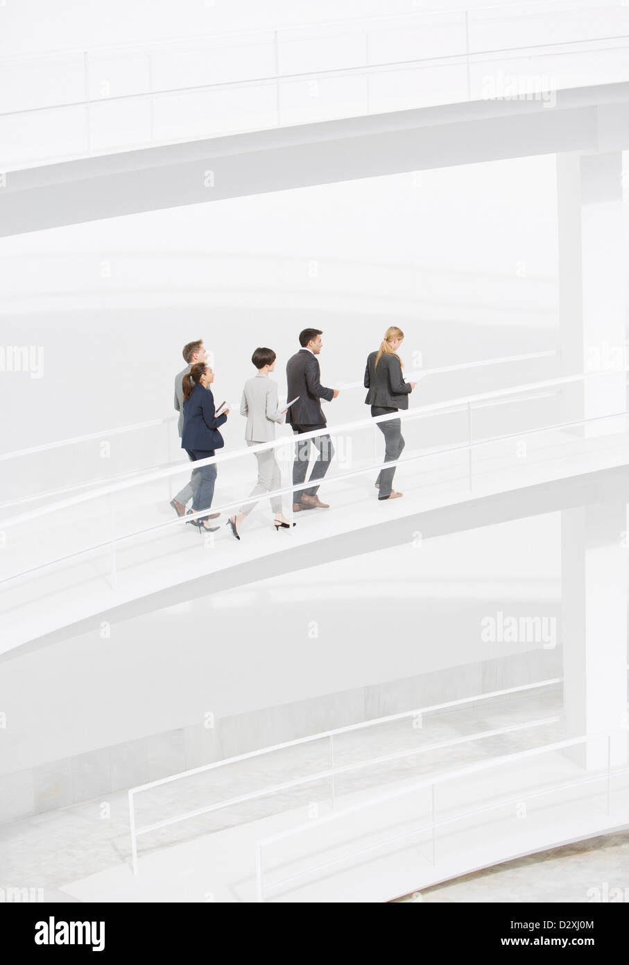 Business people walking along elevated walkway Stock Photo - Alamy