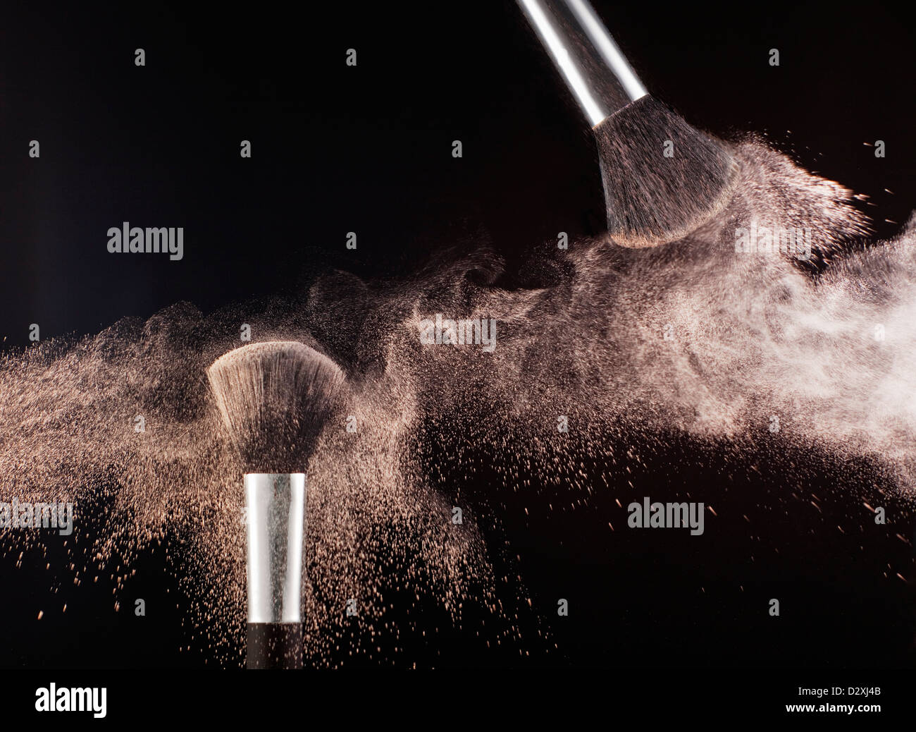 Powder blowing from makeup brushes Stock Photo