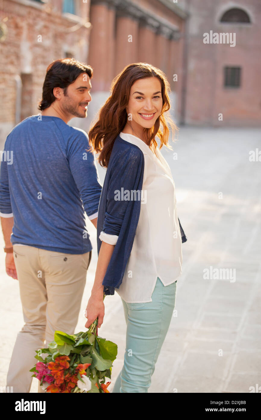 Portrait of smiling woman with boyfriend holding bouquet Stock Photo