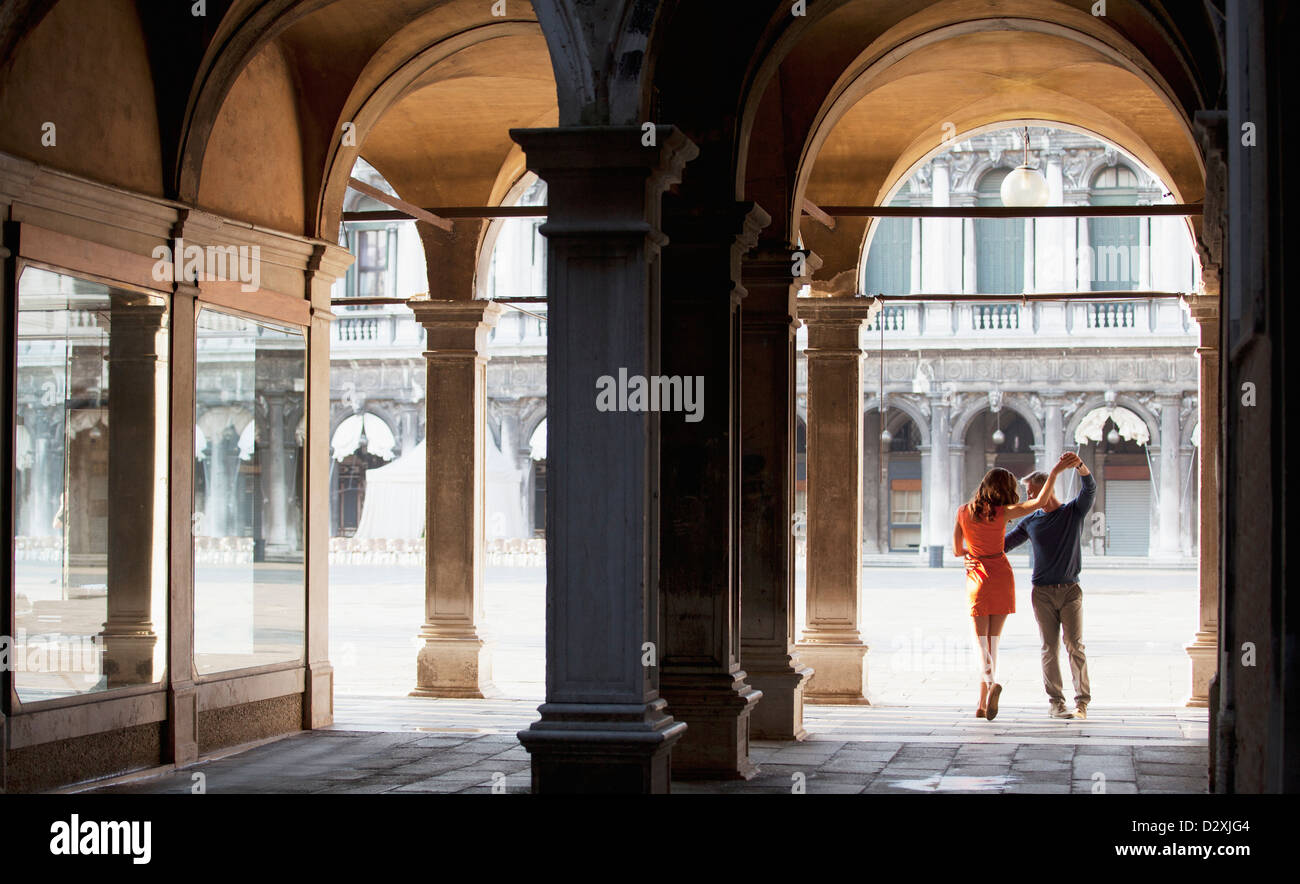 Couple dancing in archway in Venice Stock Photo