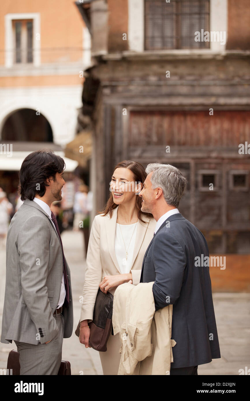 Smiling business people talking in street Stock Photo - Alamy