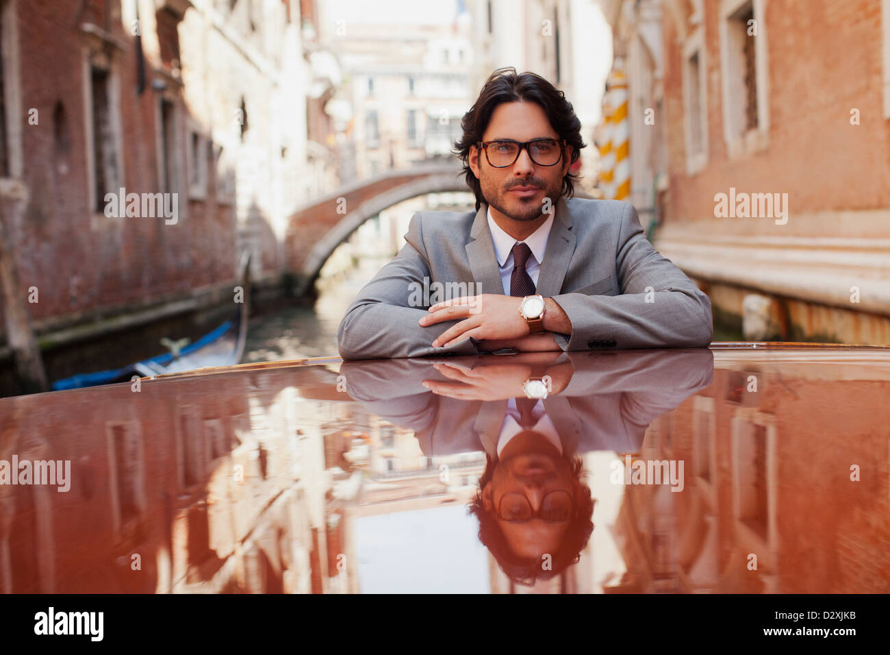 Portrait of serious businessman riding boat in canal in Venice Stock Photo