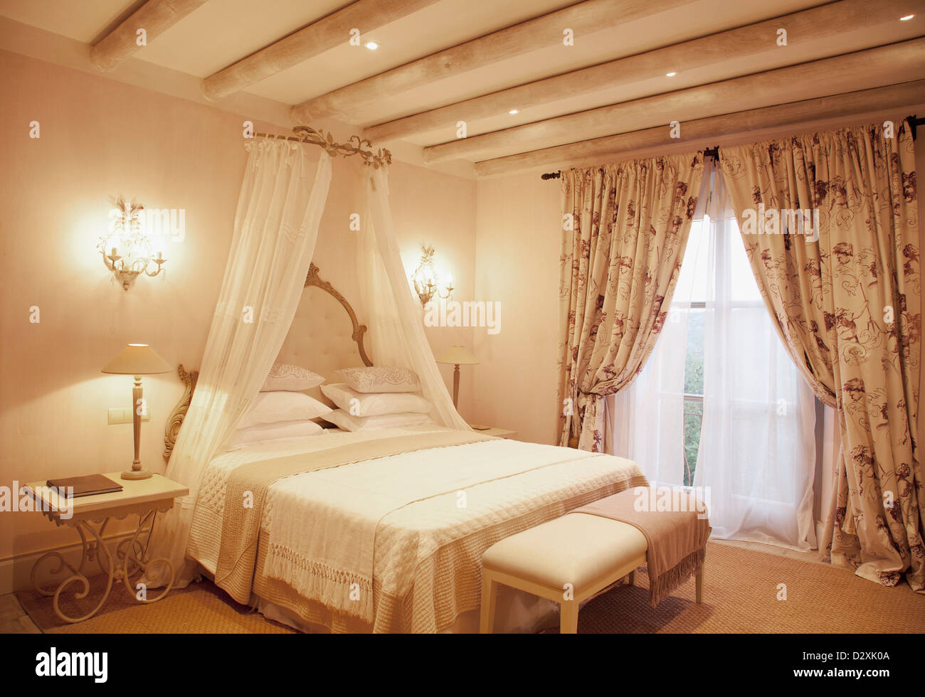 Sconces and canopy above bed in luxury bedroom Stock Photo Alamy
