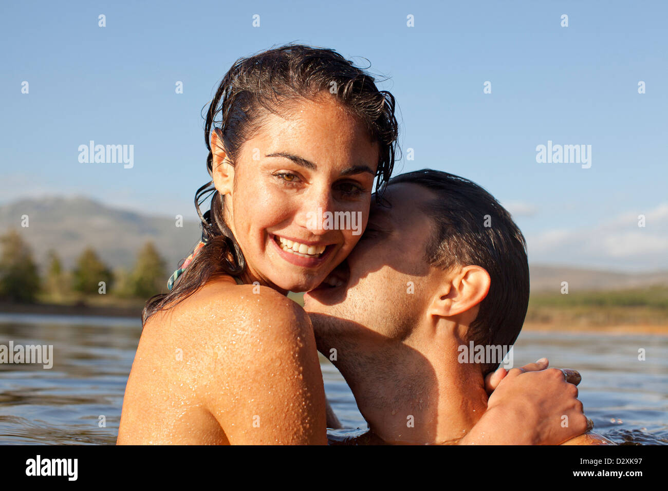 Close up portrait of couple kissing in lake Stock Photo