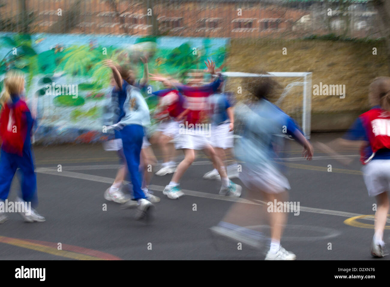 primary school children playing netball match in school playground