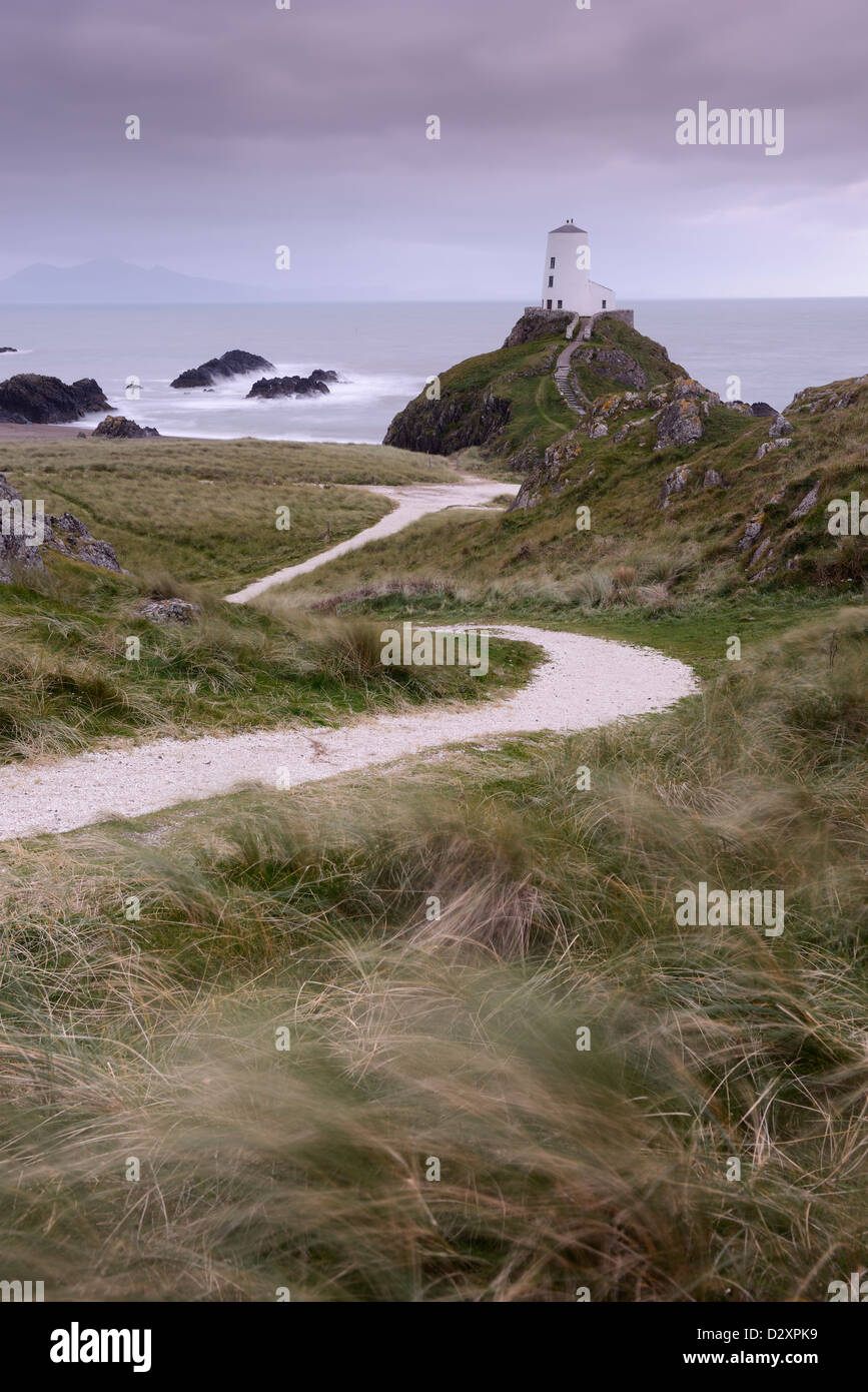 A winding path leading towards the lighthouse on the edge of Llanddwyn Island, Anglesey, Wales. Stock Photo
