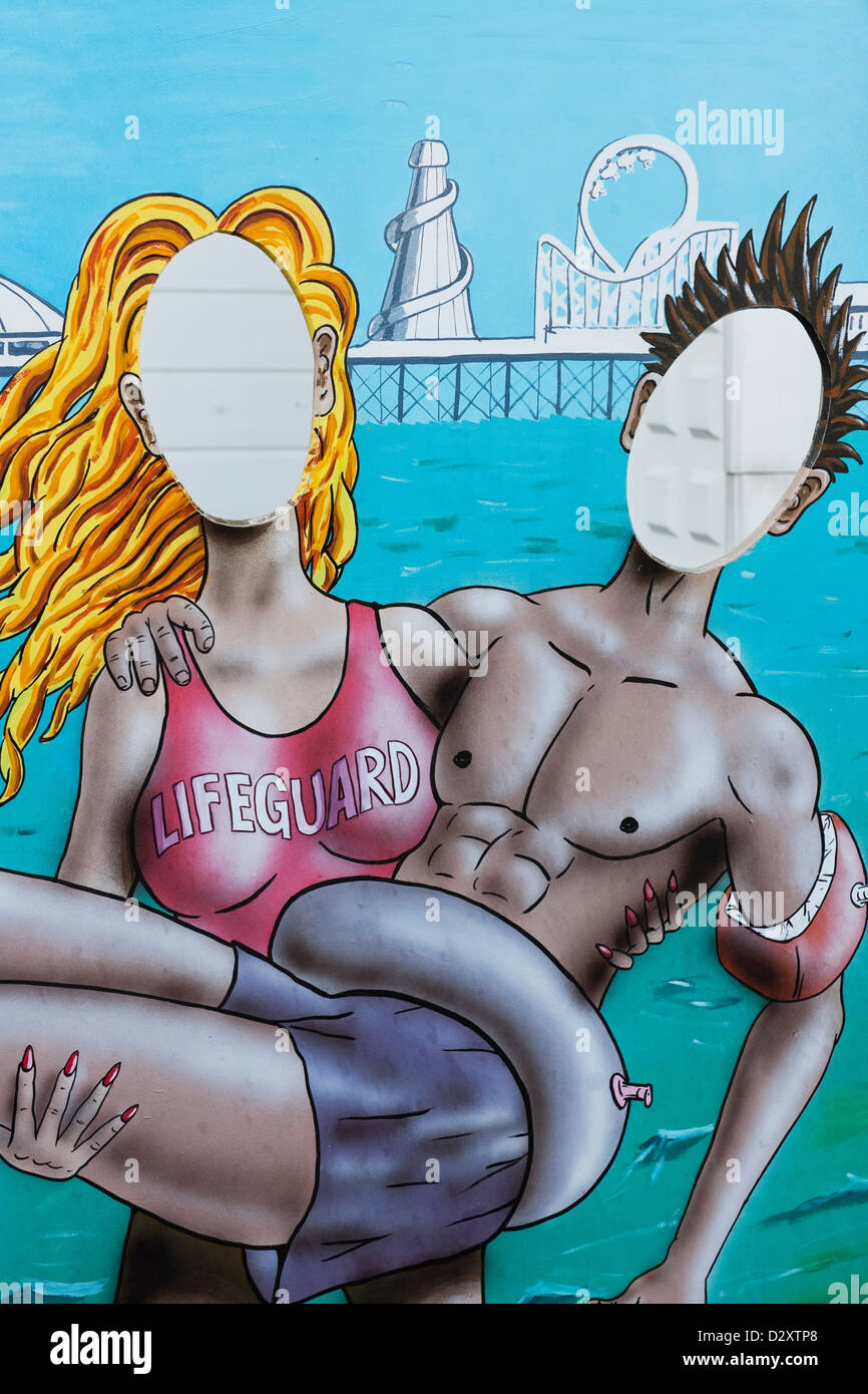 An amusing cardboard cut out showing a woman lifeguard rescuing  a  young man on  Brighton Pier East Sussex England UK Stock Photo