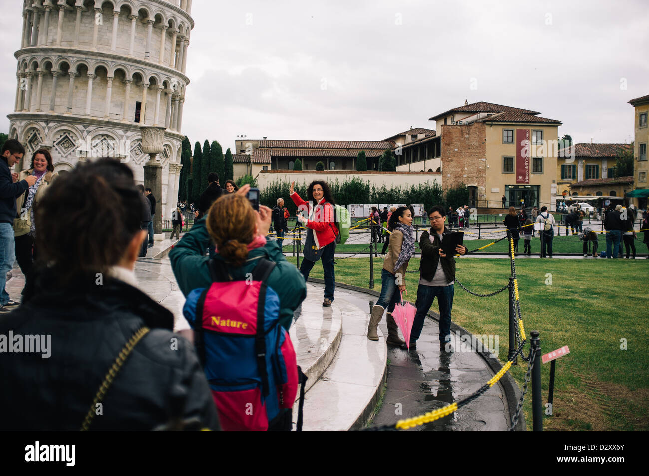 Tourists having their photos taken at he leaning tower of Pisa in the Piazza del Duomo, Italy Stock Photo