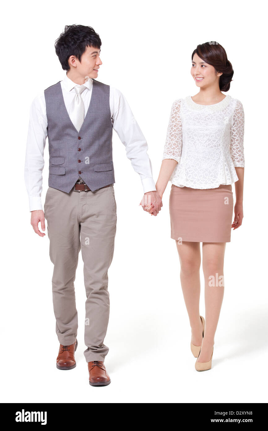 Happy young couple walking, hand in hand Stock Photo - Alamy