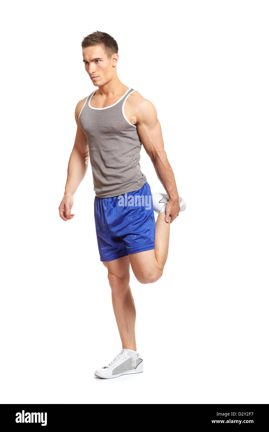 Muscular young man stretching leg in sports outfit Stock Photo