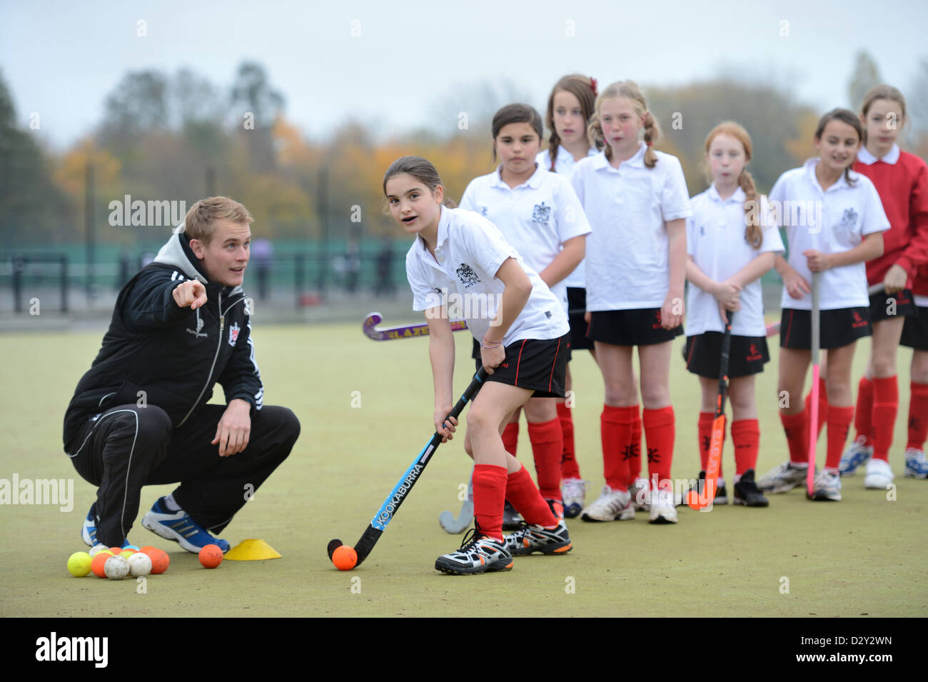 A games teacher instructs girls during hockey practice at Pates Grammar School in Cheltenham, Gloucestershire UK Stock Photo