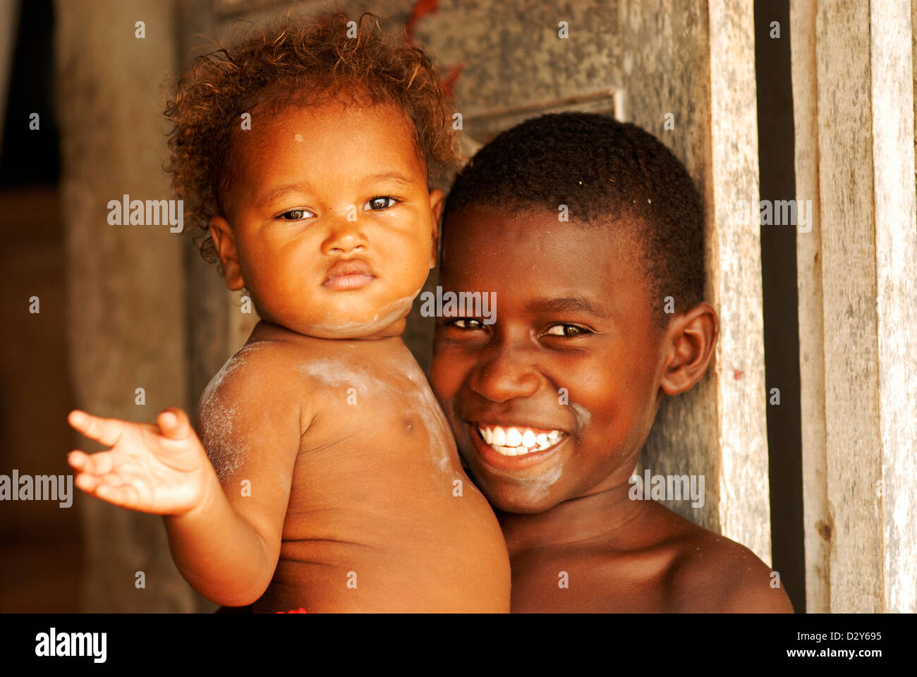 Colombia, Tierrabomba, portrait of a cheerful boy carrying cute baby