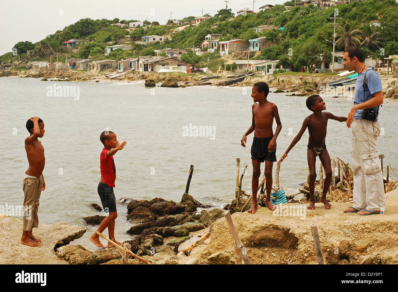 Colombia, Tierrabomba, group of black friends together near lake having fun with white man at side Stock Photo