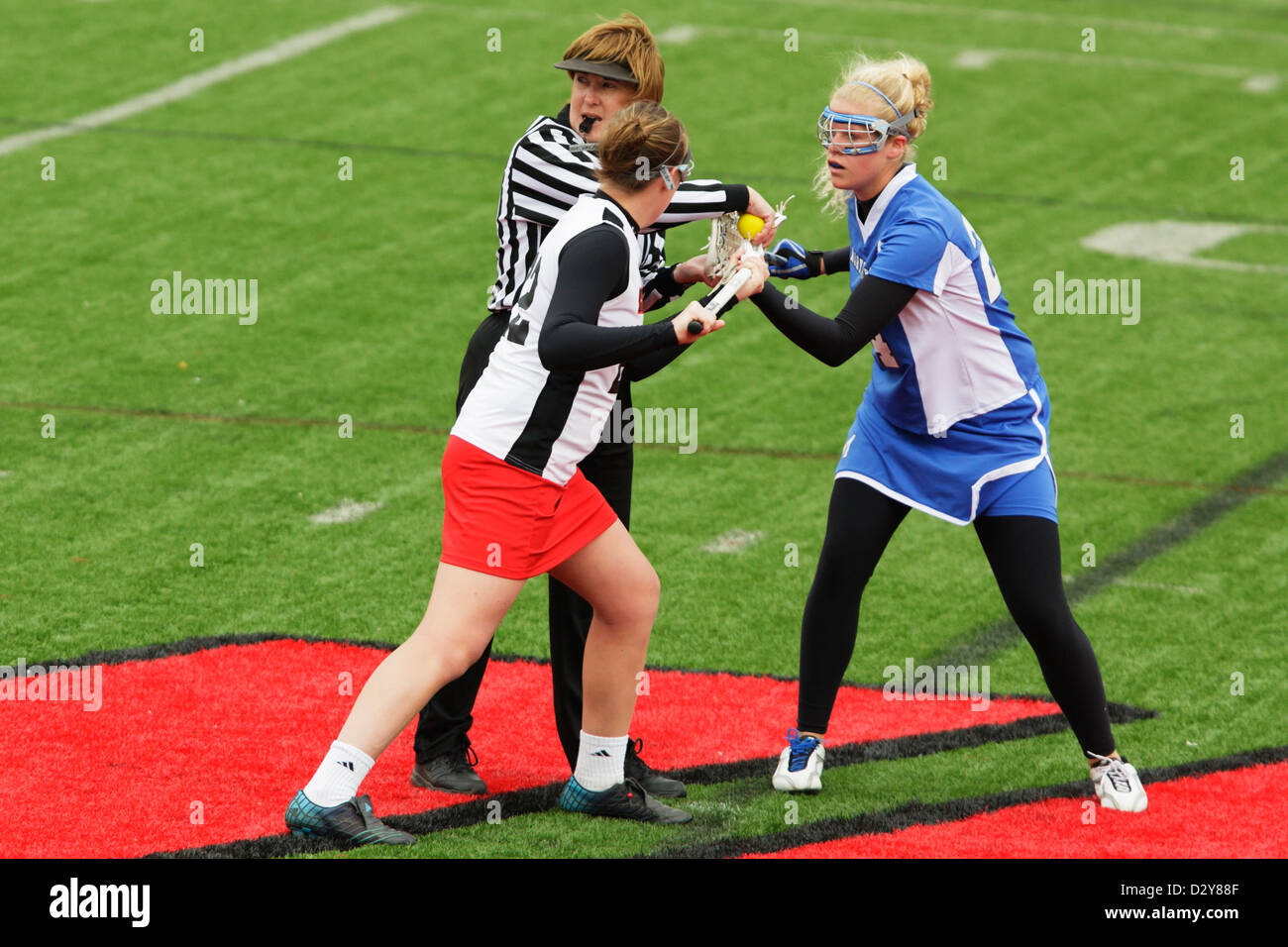 A Catholic University player (L) and Marymount University player (R) get set for a faceoff during a college lacrosse game. Stock Photo