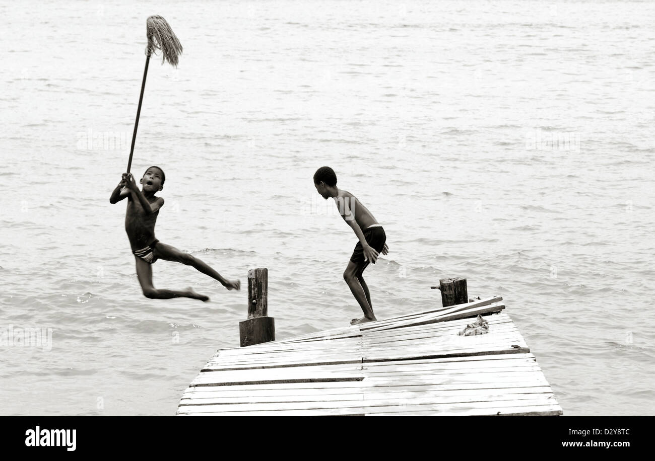 Colombia, Tierrabomba, view of young boys jumping off jetty into water ...