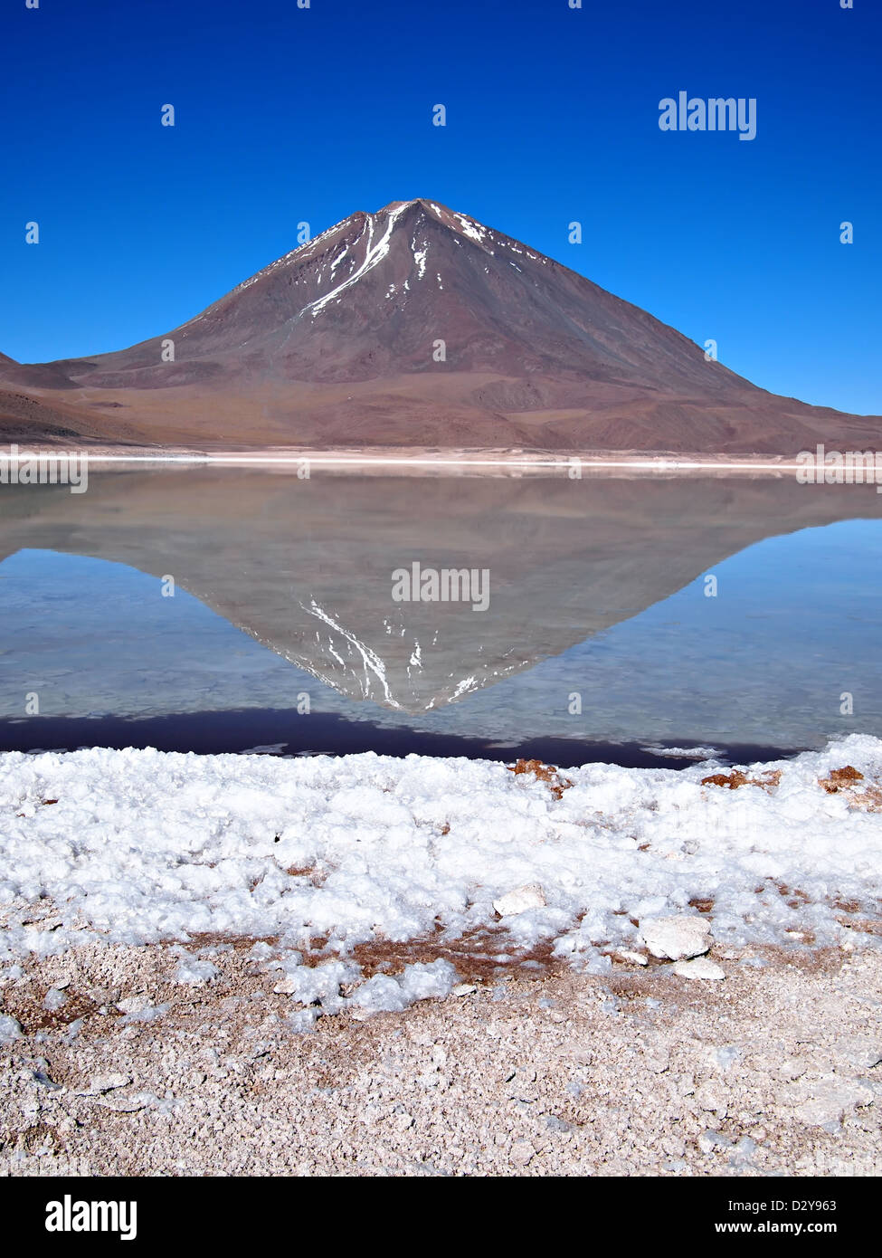 Reflection of Licancabur volcano in Laguna Verde (green lagoon) in the desert near Uyuni in Bolivia. Stock Photo