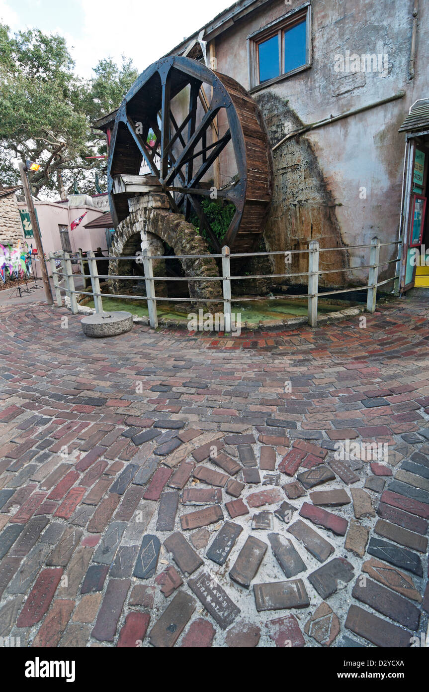 St. Augustine Florida.  Old paving bricks and a water wheel in a park setting along St. George Street in the historic district. Stock Photo