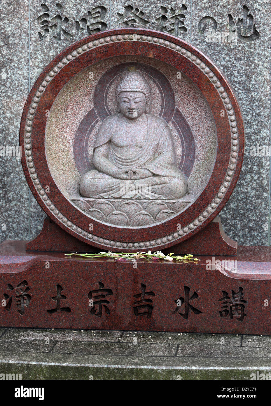 Tokyo, Japan, grave with Buddha figure in the cemetery on Zojoji