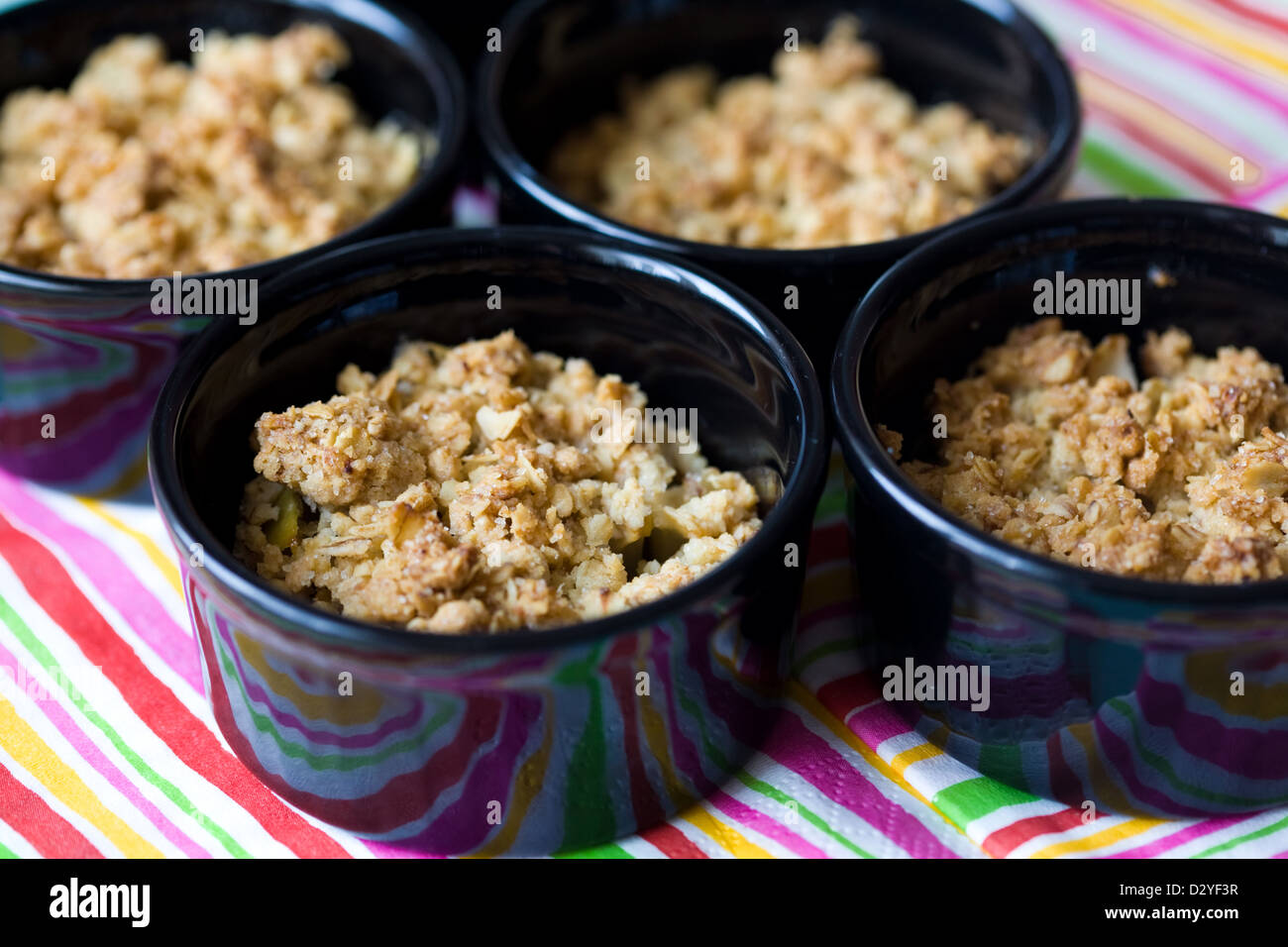Home made apple crumble in black containers Stock Photo Alamy