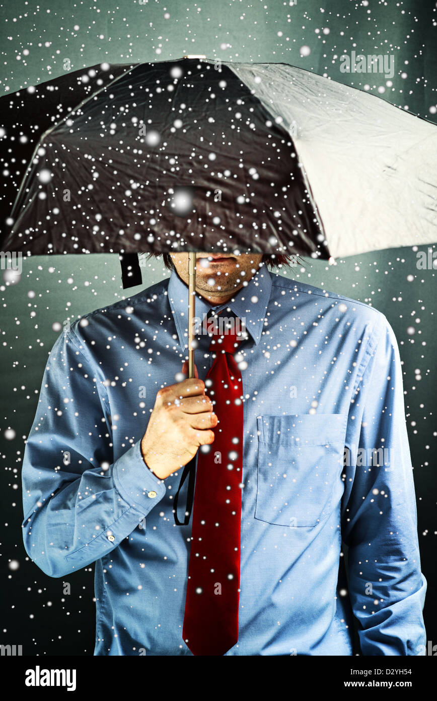 Businessman with black umbrella protecting himself from the storm ...