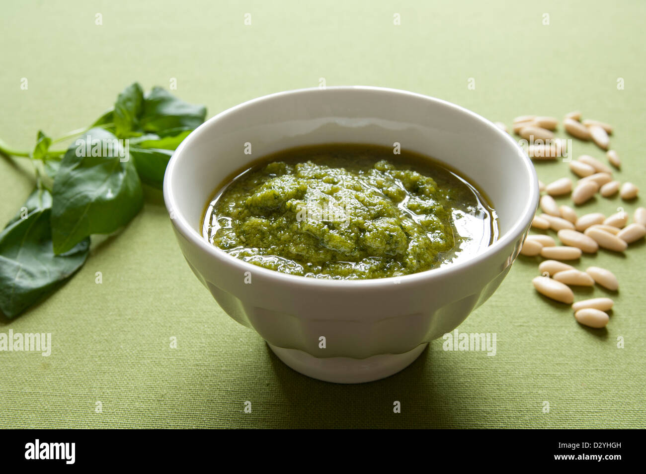Close-up view of organic italian traditional Pesto sauce in a bowl with basil and pine nut Stock Photo