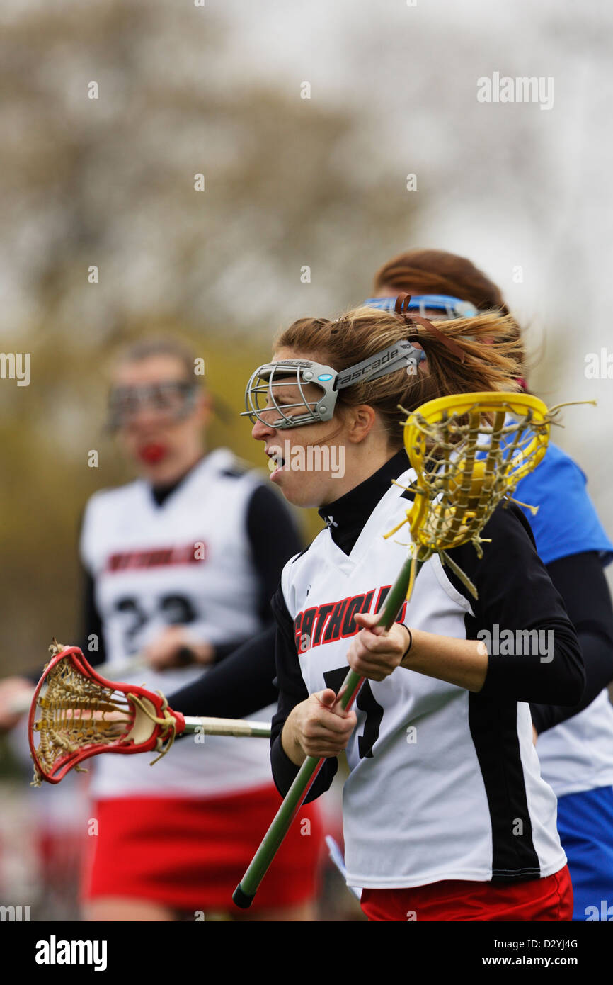 A Catholic University player cradles the ball during a lacrosse game against Marymount University. Stock Photo
