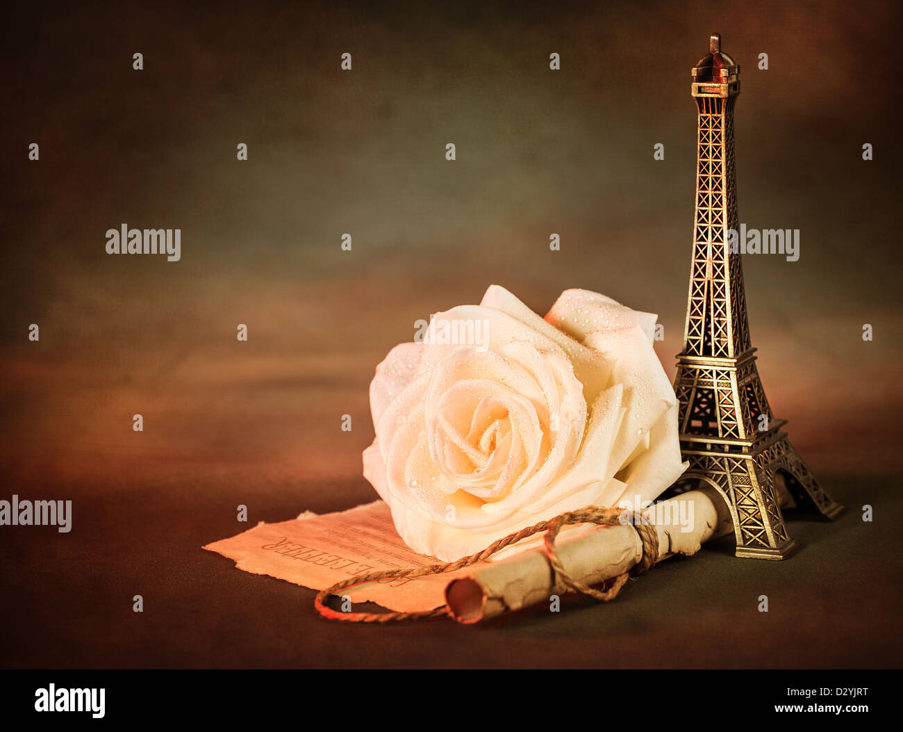 Picture of beautiful still life, old paper scroll with white rose on the table and little Eiffel tower souvenir Stock Photo