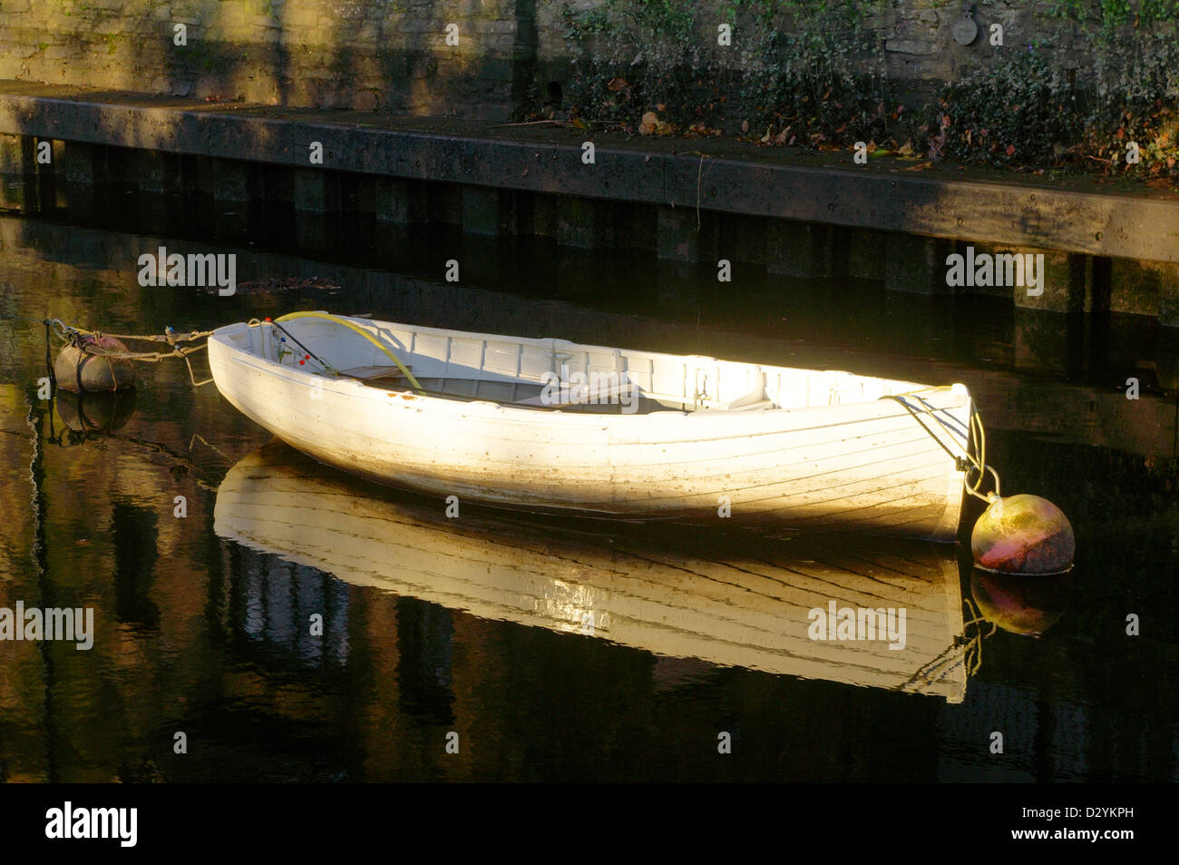 White wooden rowing boat on the River Dart at Totnes in the early morning light Stock Photo