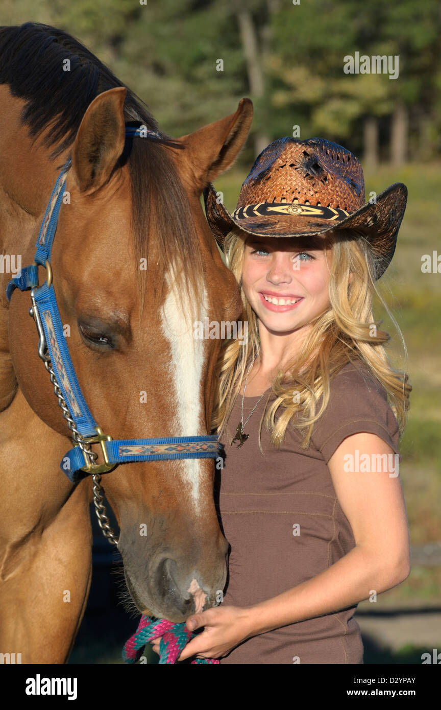 Girl with horse in close up portrait, pretty blond in cowboy hat, summer evening in Pennsylvania, PA, USA. Stock Photo