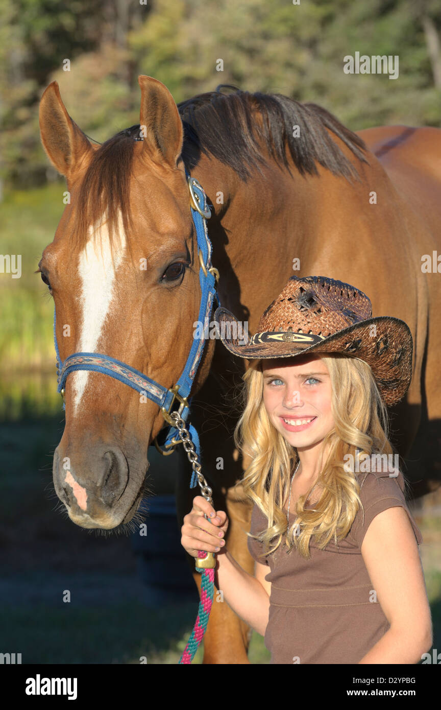 Girl with horse in close up portrait, pretty blond in cowboy hat, summer evening in Pennsylvania, PA, USA. Stock Photo