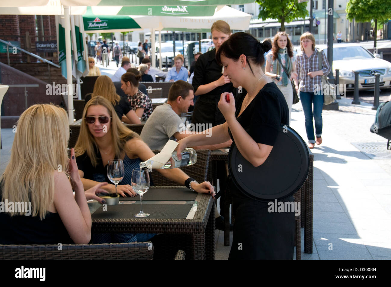 A waitress taking a lunch order at one of the many eateries in Town Hall Square, Vilnius old town, Vilnius, Lithuania Stock Photo