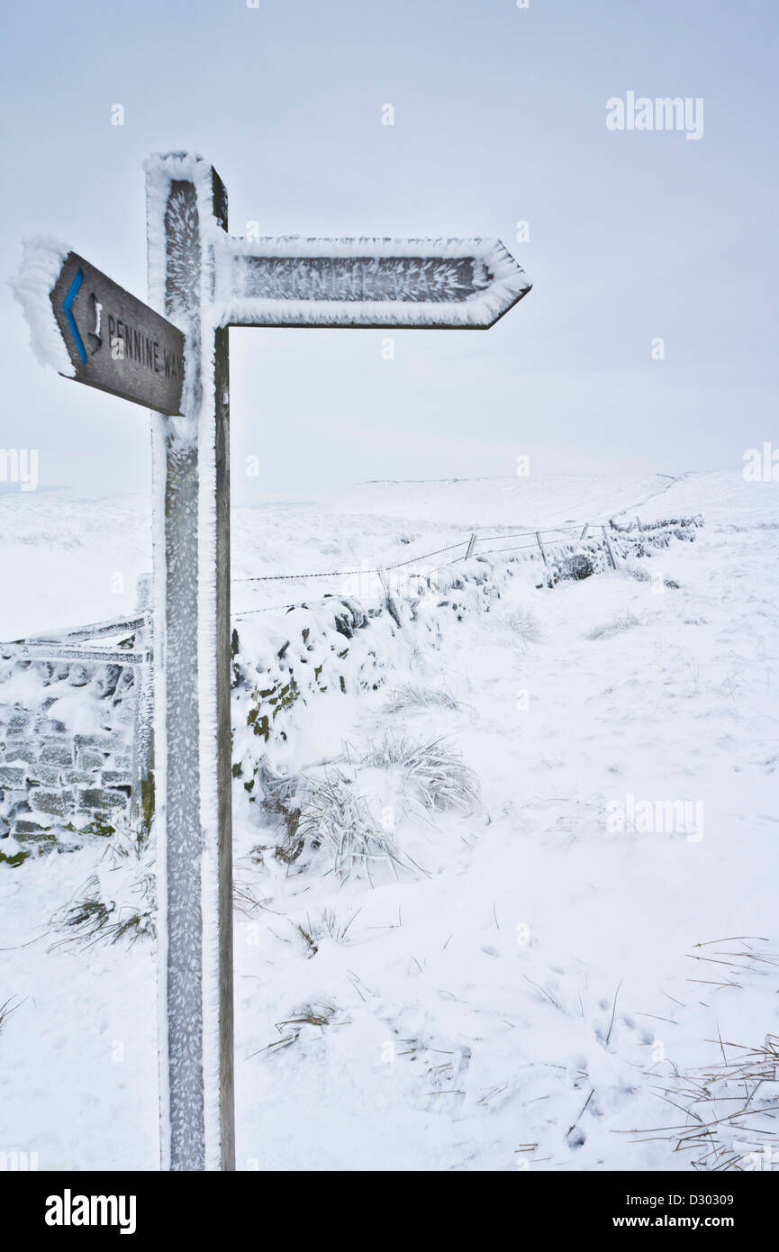 snow and ice covered signpost giving directions to the pennine way Edale cross Kinder scout Derbyshire peak district England UK Stock Photo