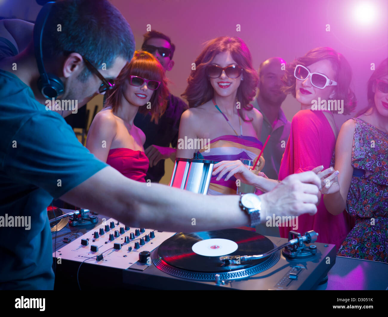 male dj playing music with turntables and headphones at a party with ...