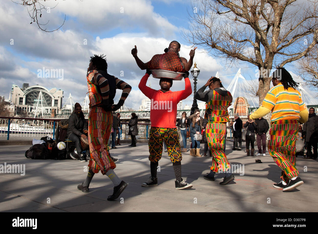 A walk along the River Thames on the Southbank in London. African acrobatics street entertainers perform. Stock Photo
