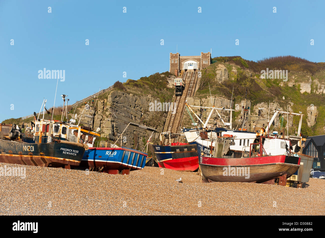 Fishings boats on The Stade in Hastings, East Sussex, England, UK - with the funicular railway behind Stock Photo