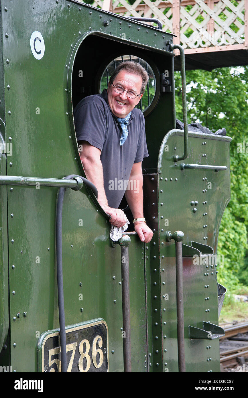 Steam locomotive fireman engine driver enjoying his work Stock Photo