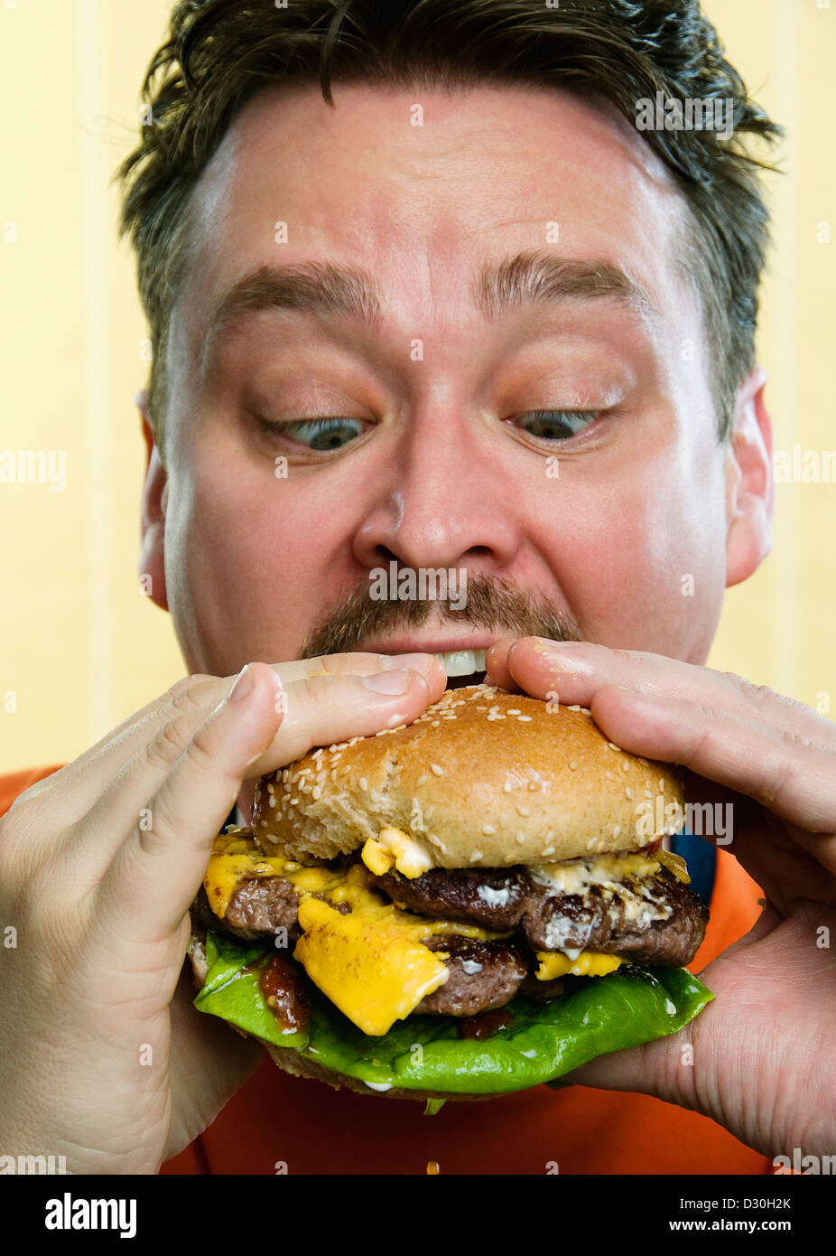 A man eating a messy hamburger Stock Photo