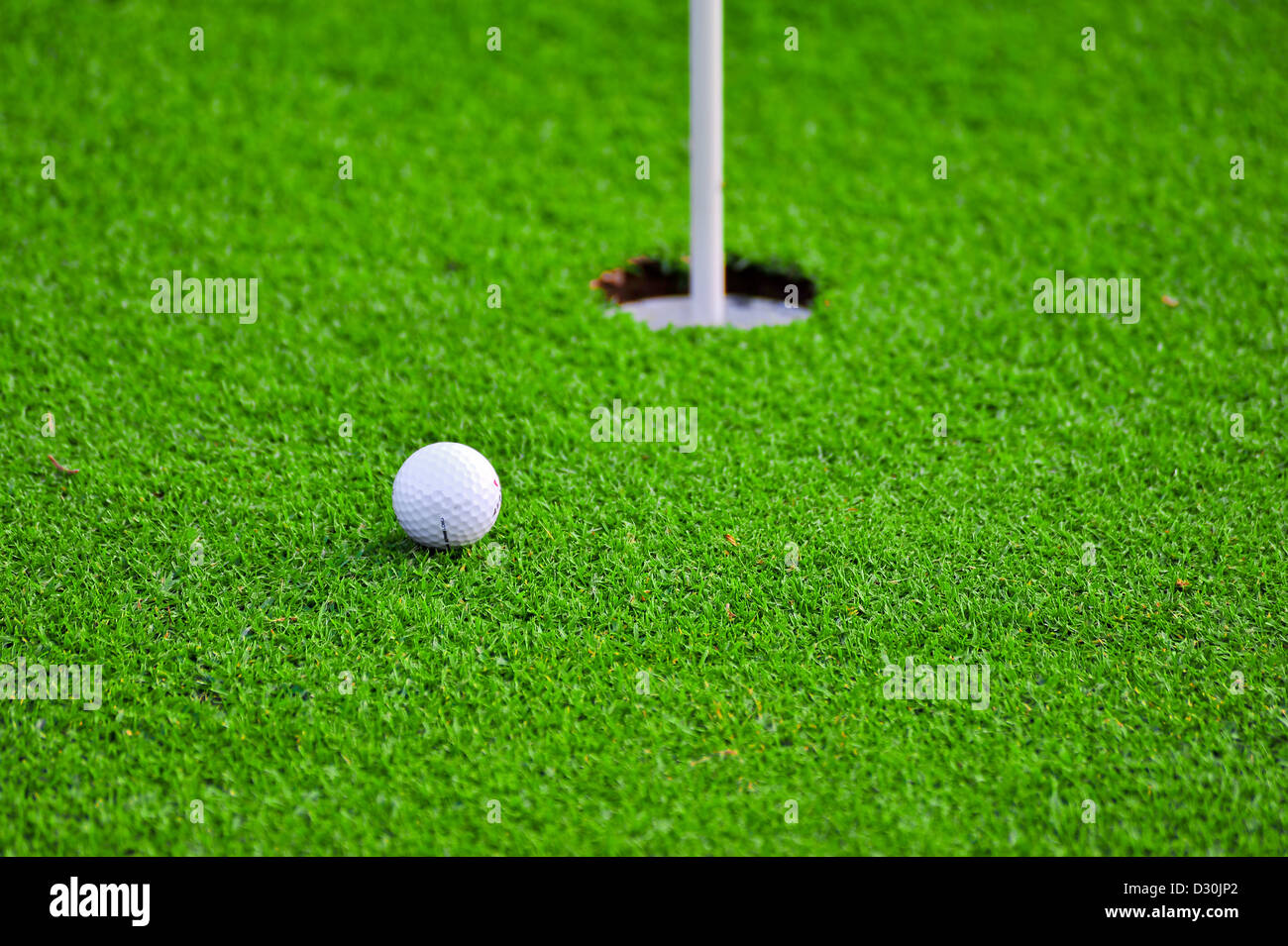 A white golf ball near the hole Stock Photo Alamy