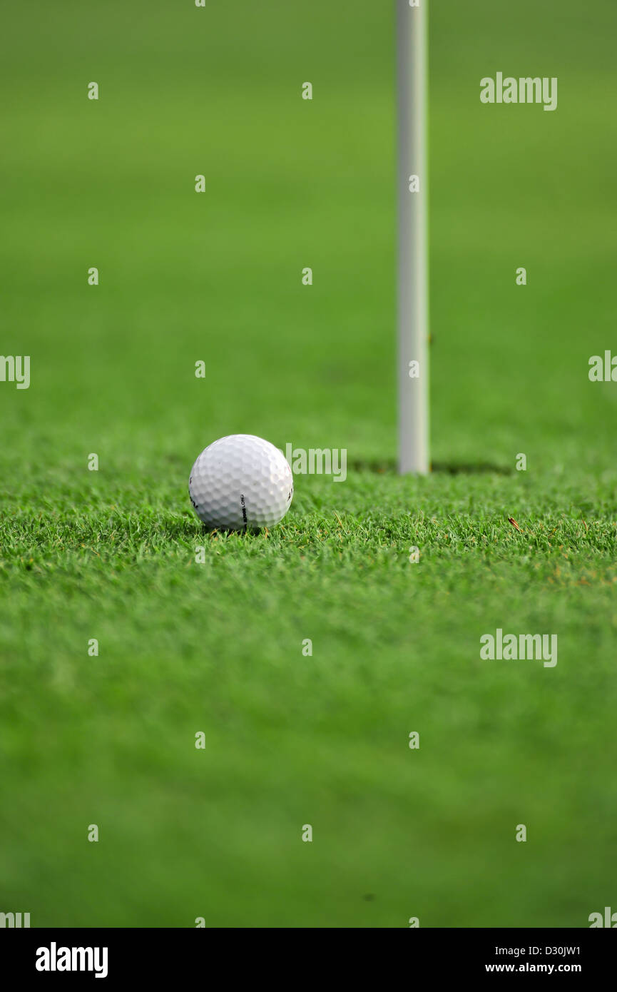 A white golf ball near the hole Stock Photo Alamy