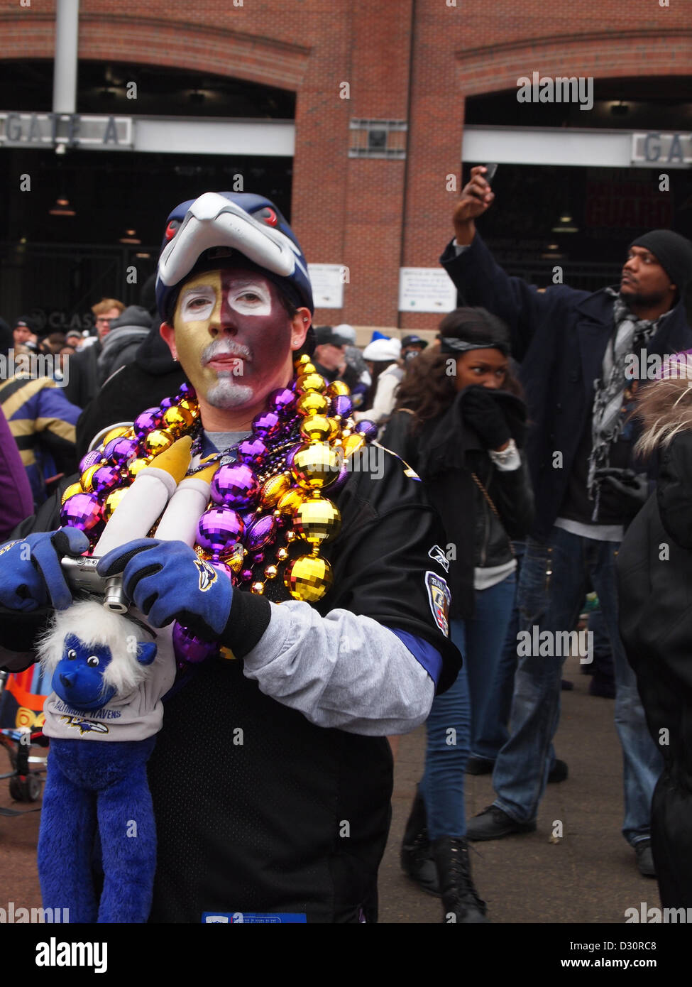 A Baltimore Ravens football team fan celebrates while wearing festive beads and makeup in the teams purple and gold colors outside the Ravens M and T Bank Stadium in Baltimore, Maryland on Feb. 5, 2013. Stock Photo