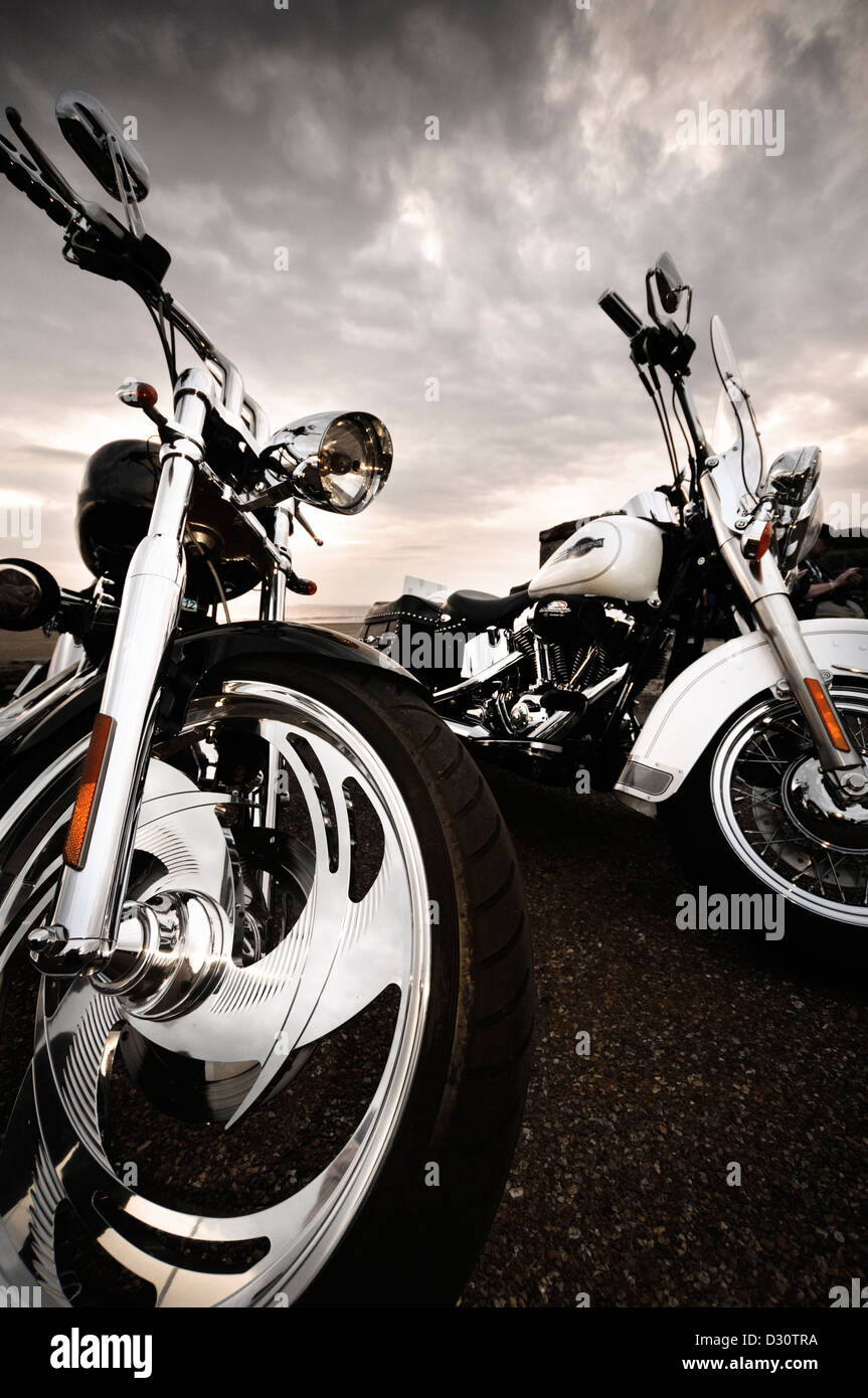 Custom Harley Davidson motorcycles parked with overcast sky in the background. Stock Photo