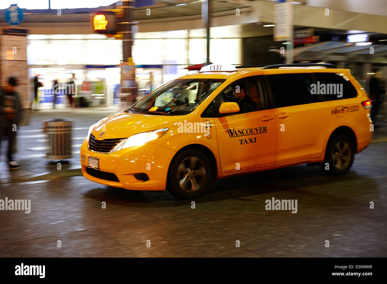 yellow cab taxi downtown Vancouver city shopping area at night BC Canada deliberate motion blur Stock Photo