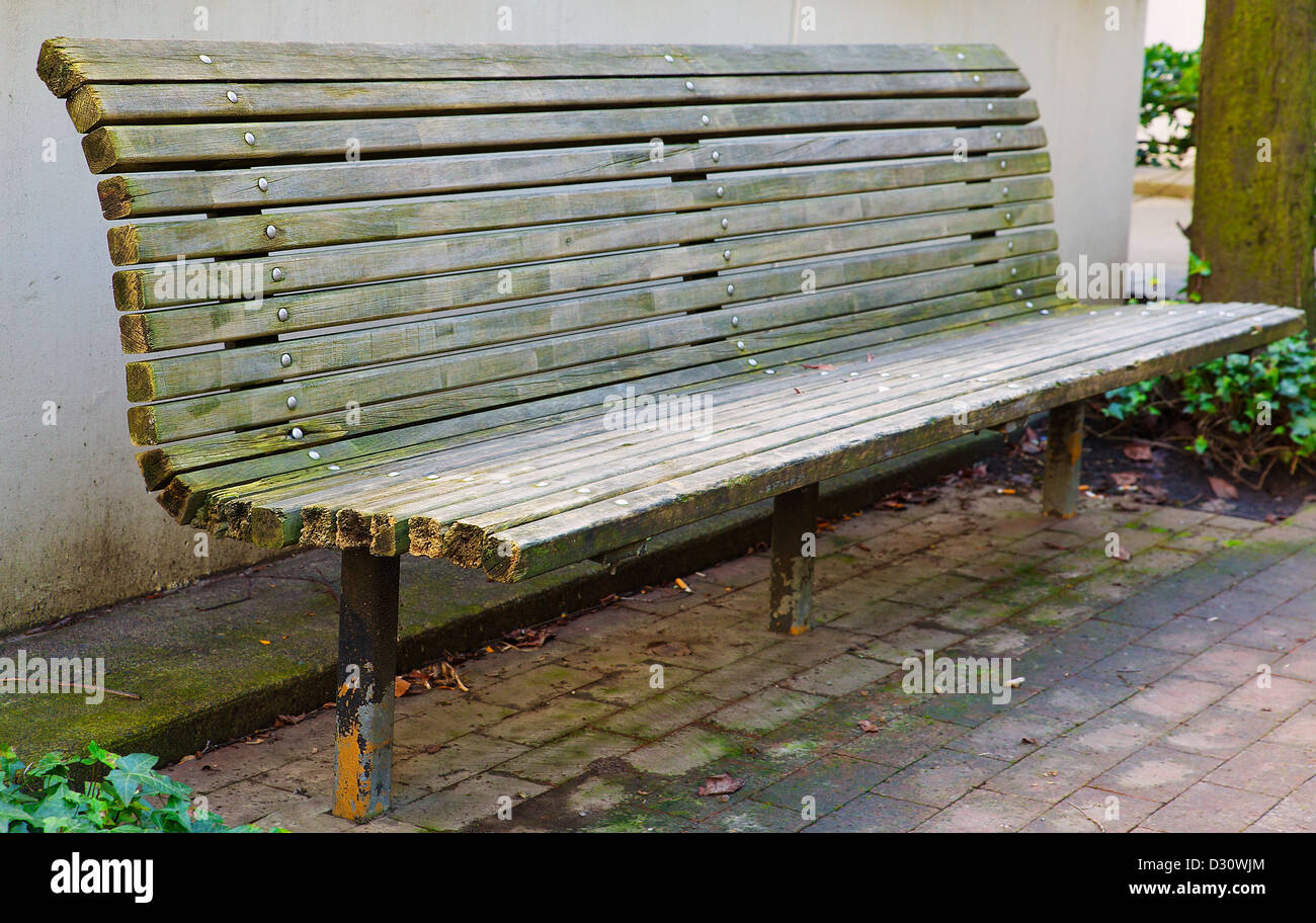 City Park Bench Perspective Against Tan Building Wall Stock Photo