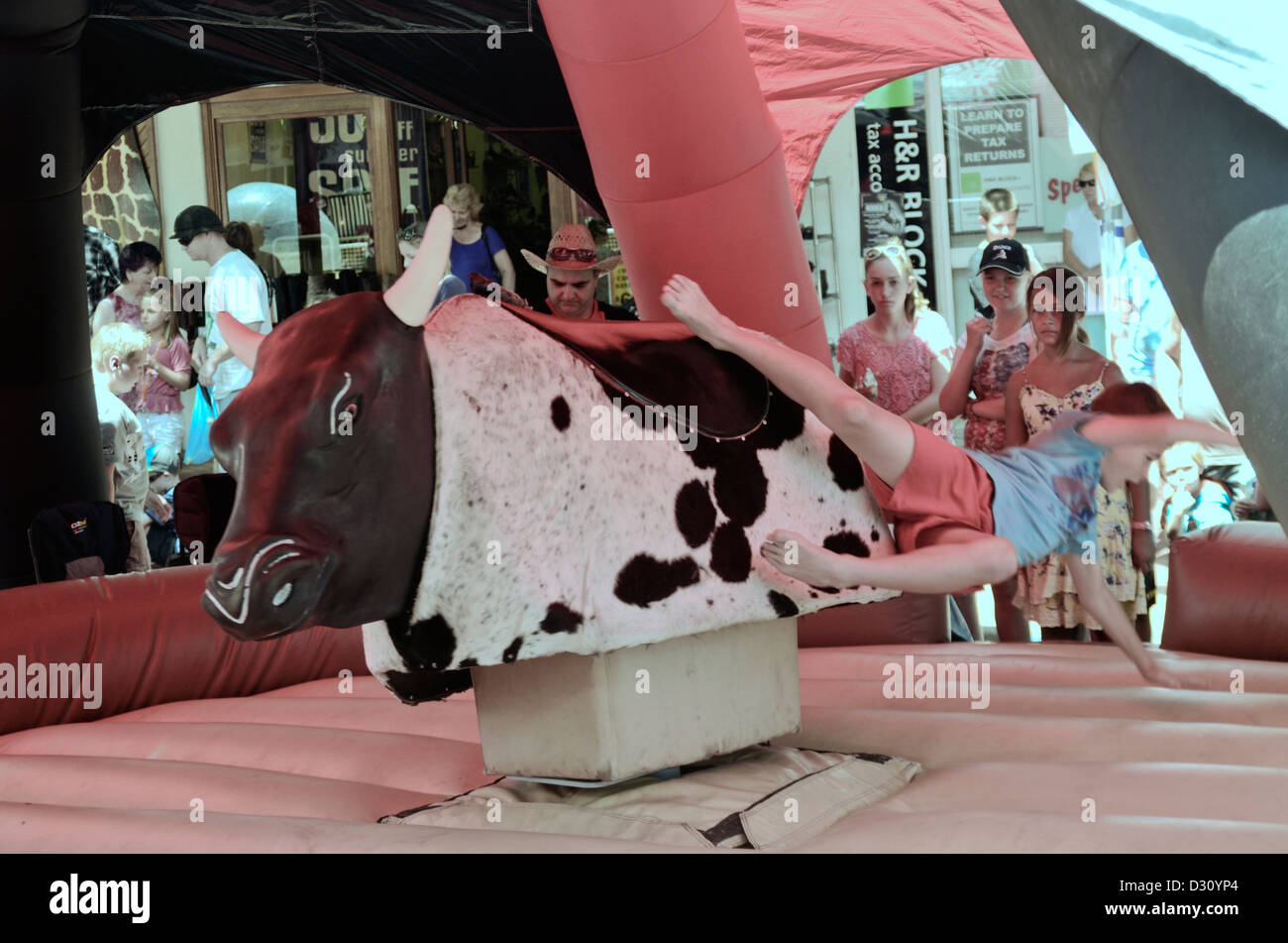 Boy falling off a mechanical bull. Tamworth Australia street festival 2013 Stock Photo