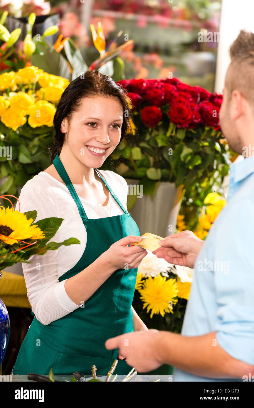 Smiling florist man customer buying flowers credit card shop Stock