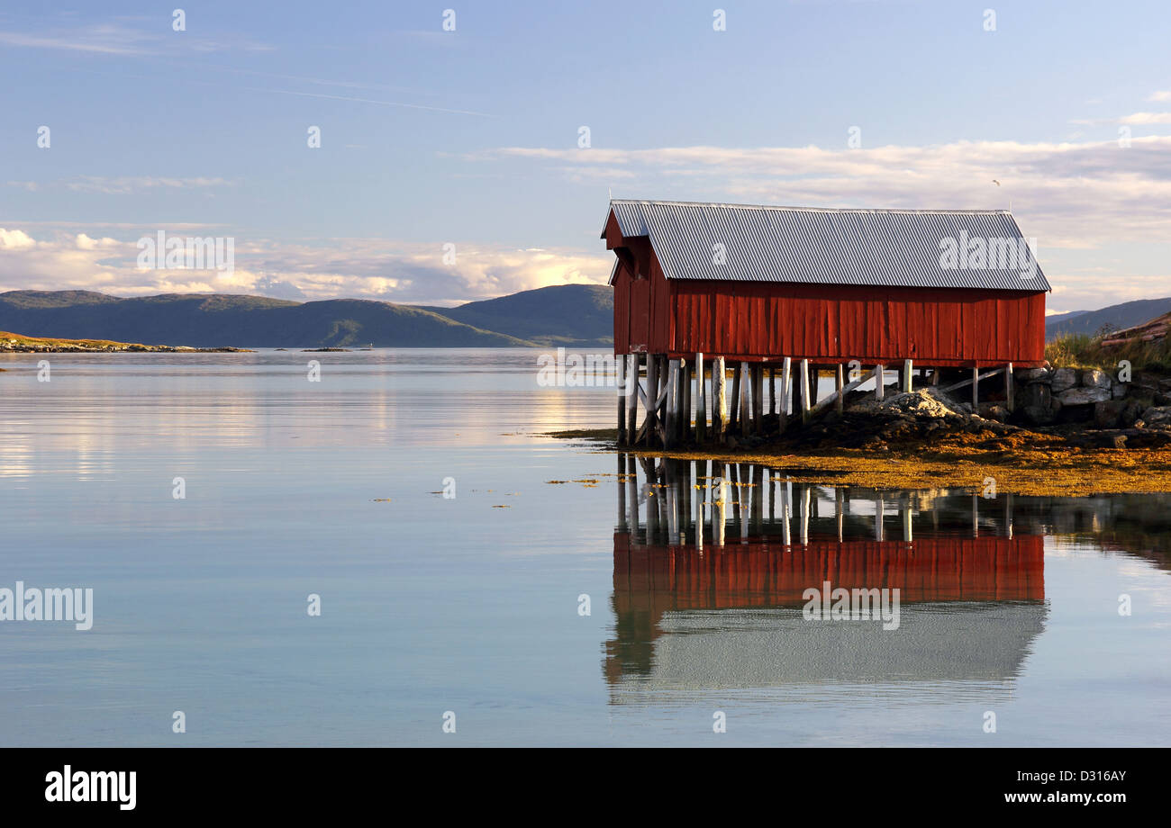Colorful boat house reflected in the calm fjord waters Stock Photo