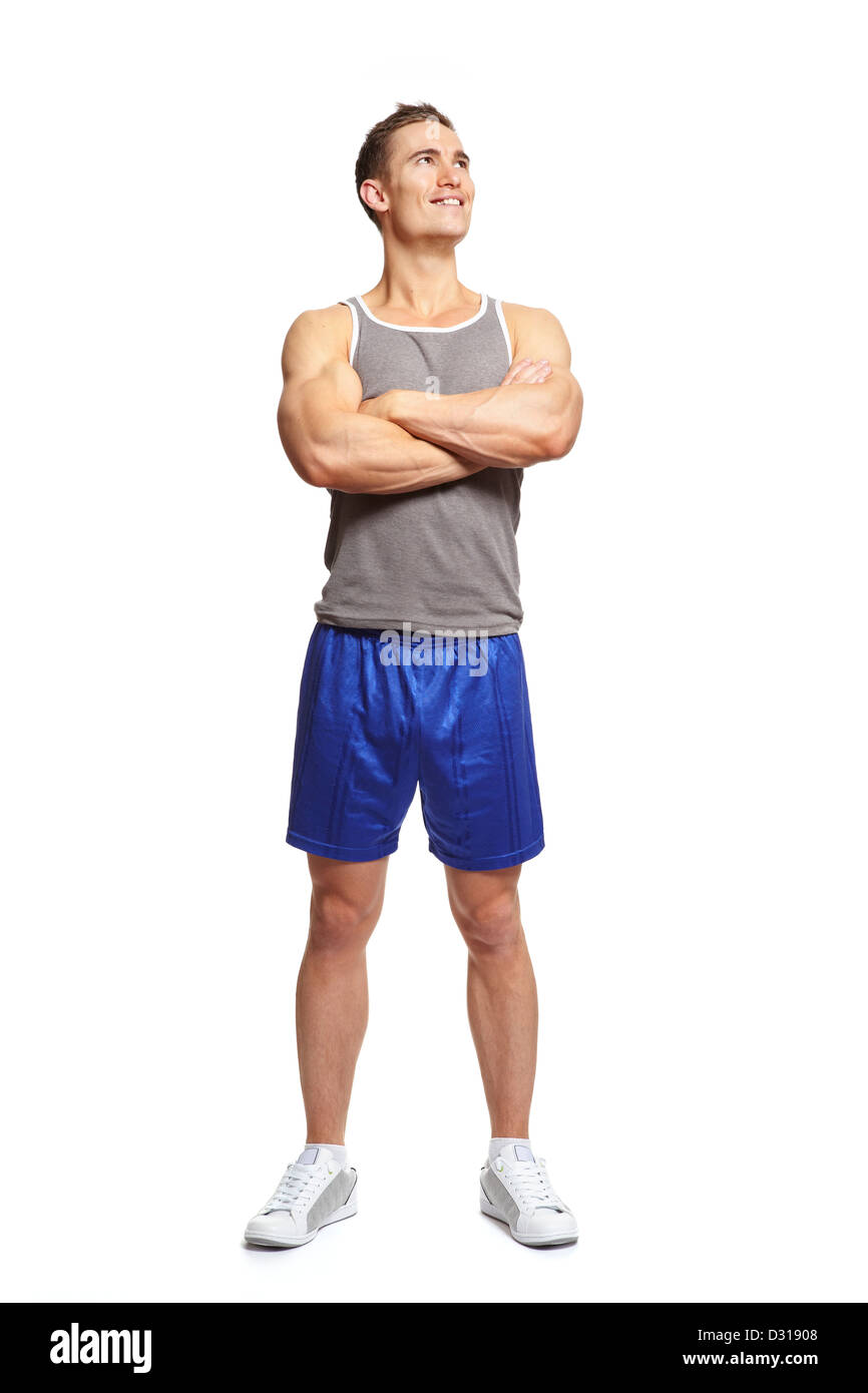 Muscular young man in sports outfit arms folded looking up on white background Stock Photo